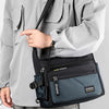 A woman wearing a light gray jacket holds a black multifunctional crossbody bag.