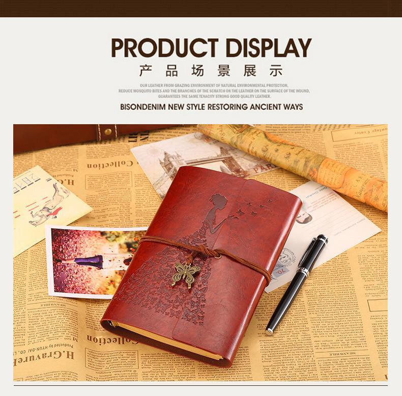 A brown leather journal notebook with a decorative clasp rests on aged paper and a quill pen.