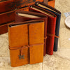 A set of vintage butterfly PU leather A6 journal notebooks in various shades of brown and red stacked on a map background.