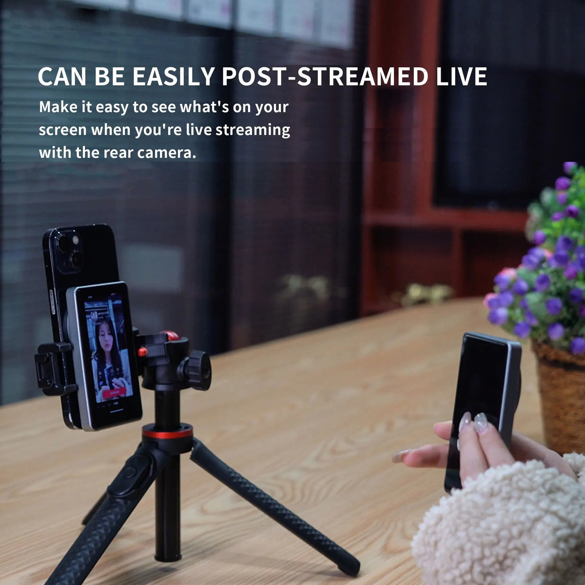 A smartphone is mounted on a tripod, showing a magnetic phone rear camera monitor for live streaming.