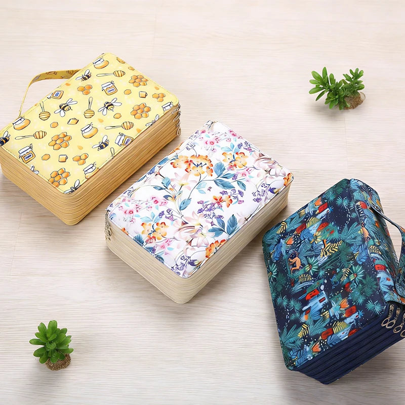 A set of three large capacity pencil cases featuring floral and geometric patterns on a light wood background.