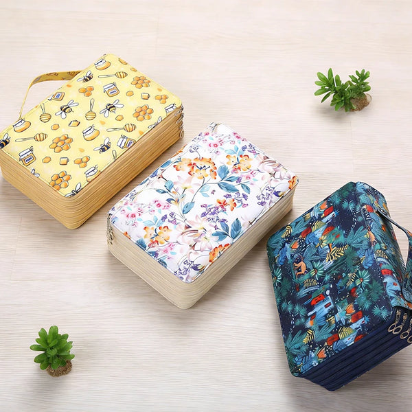 A set of three large capacity pencil cases featuring floral and geometric patterns on a light wood background.