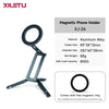 A dark gray magnetic phone holder with a circular ring and adjustable arms.