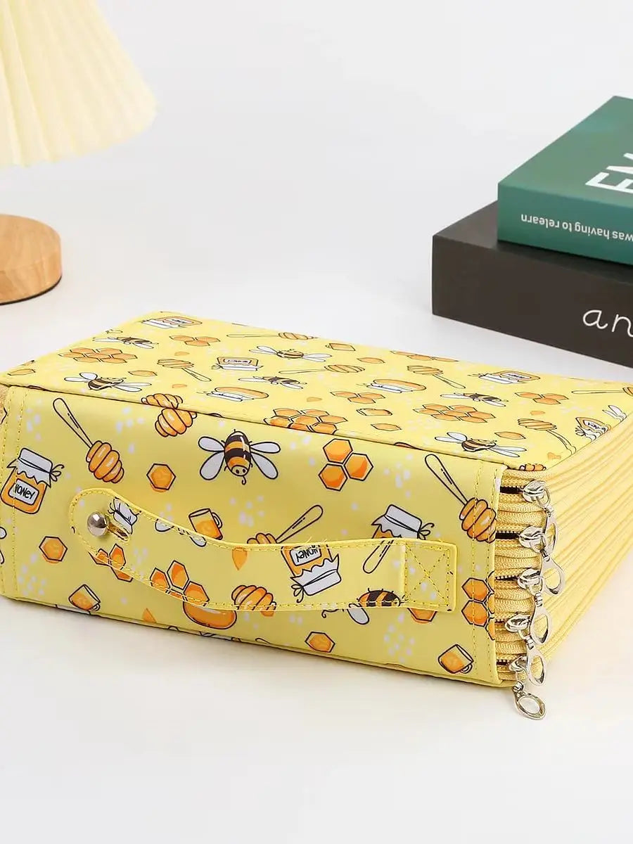 A yellow pencil case with bee and honeycomb patterns is shown on a white surface.