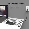 A black 65W Type-C fast charger power cord plugged into a laptop and lying on a white surface.