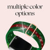 A green and red glitter nylon strap for an Apple Watch is shown next to a smartphone.