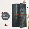 A dark gray cylindrical notebook with a leather texture and a brown cord tied around it, featuring butterfly designs.