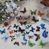 A collection of colorful butterfly wings in various colors and patterns laid on a beige surface.