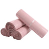 Pink waterproof self-seal poly mail bags rolled up and laid diagonally