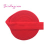 A red bristleglass hair tie with a wide elastic band shown flat.