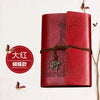 A red leather journal notebook with embossed butterfly designs and a leather tie.