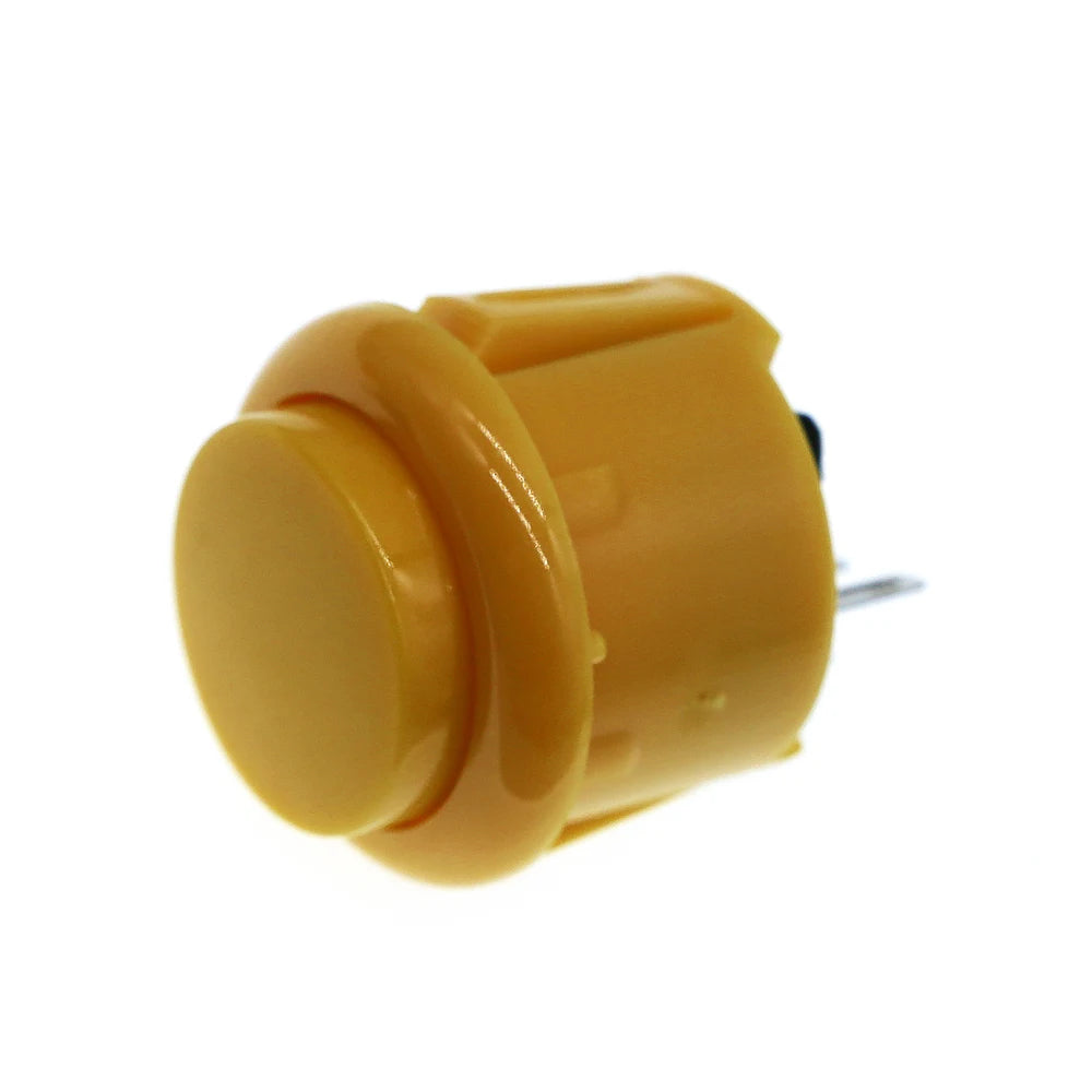 A yellow arcade push button game switch with a round top and a small metal pin visible.