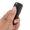 A hand is holding a black realistic fake car key hidden safe with a secret compartment.