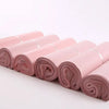 Rolls of pink waterproof self-seal poly mail bags arranged in a line.