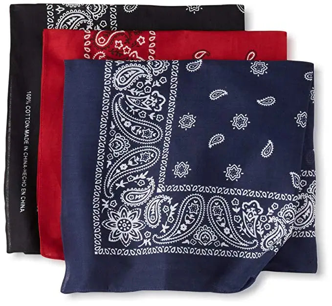 A stack of three dark blue and red paisley print cotton bandana square scarves.