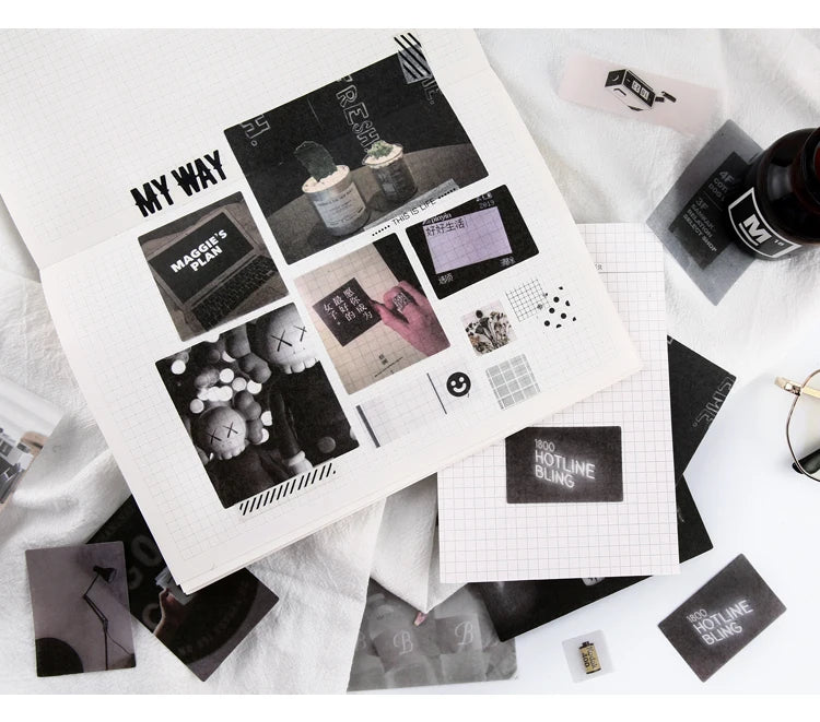 A collection of black and white stickers, including a map, a pink hand, and various small elements, displayed on a white pape