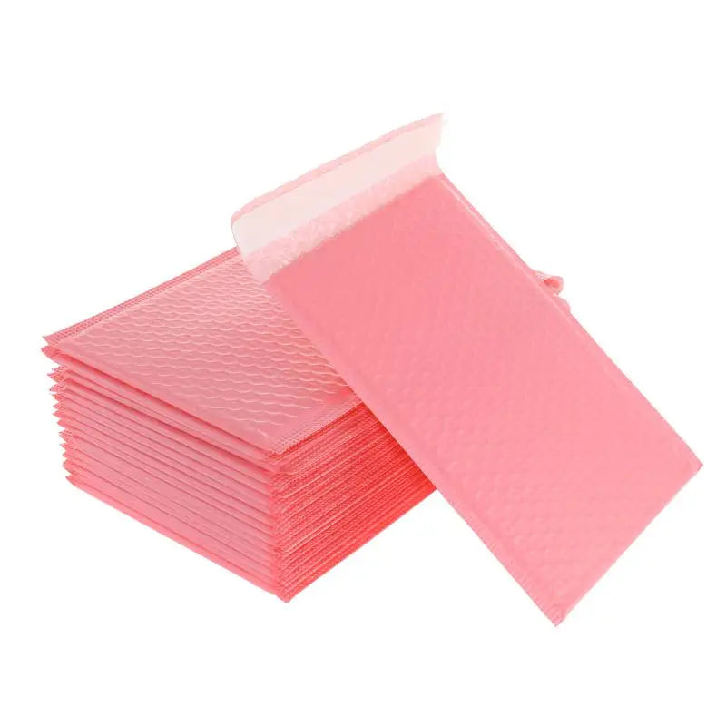 A stack of pink self-sealing bubble mailers, padded envelopes, ready for mailing.