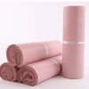 Rolls of pink waterproof self-seal poly mail bags stacked and standing upright.