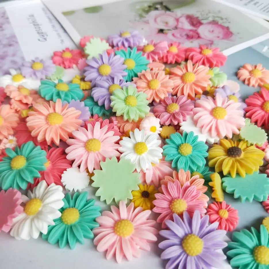 A colorful assortment of pink, purple, yellow, and green sunflower flatback resin cabochons for crafts.