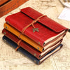 A stack of vintage red and brown PU leather A6 journal notebooks tied with leather thongs on a map background.