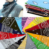 A collection of colorful paisley print cotton bandana square scarves folded and displayed.