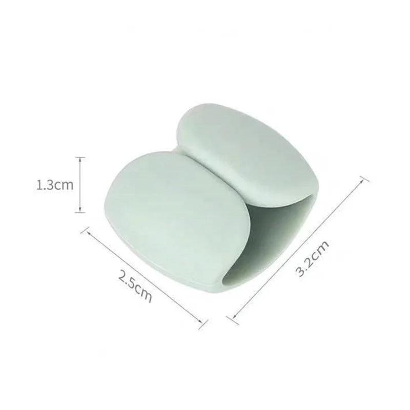 A white silicone cable organizer clip with dimensions 1.3cm by 3.2cm.