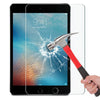 A hand holds a red and silver hammer next to an iPad screen protected by a clear tempered glass screen protector.
