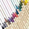 A collection of 15 paintbrushes in various colors, including pinks, greens, yellows, and browns, arranged diagonally.