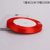 A roll of red satin ribbon with white stuffing is shown on a white background.