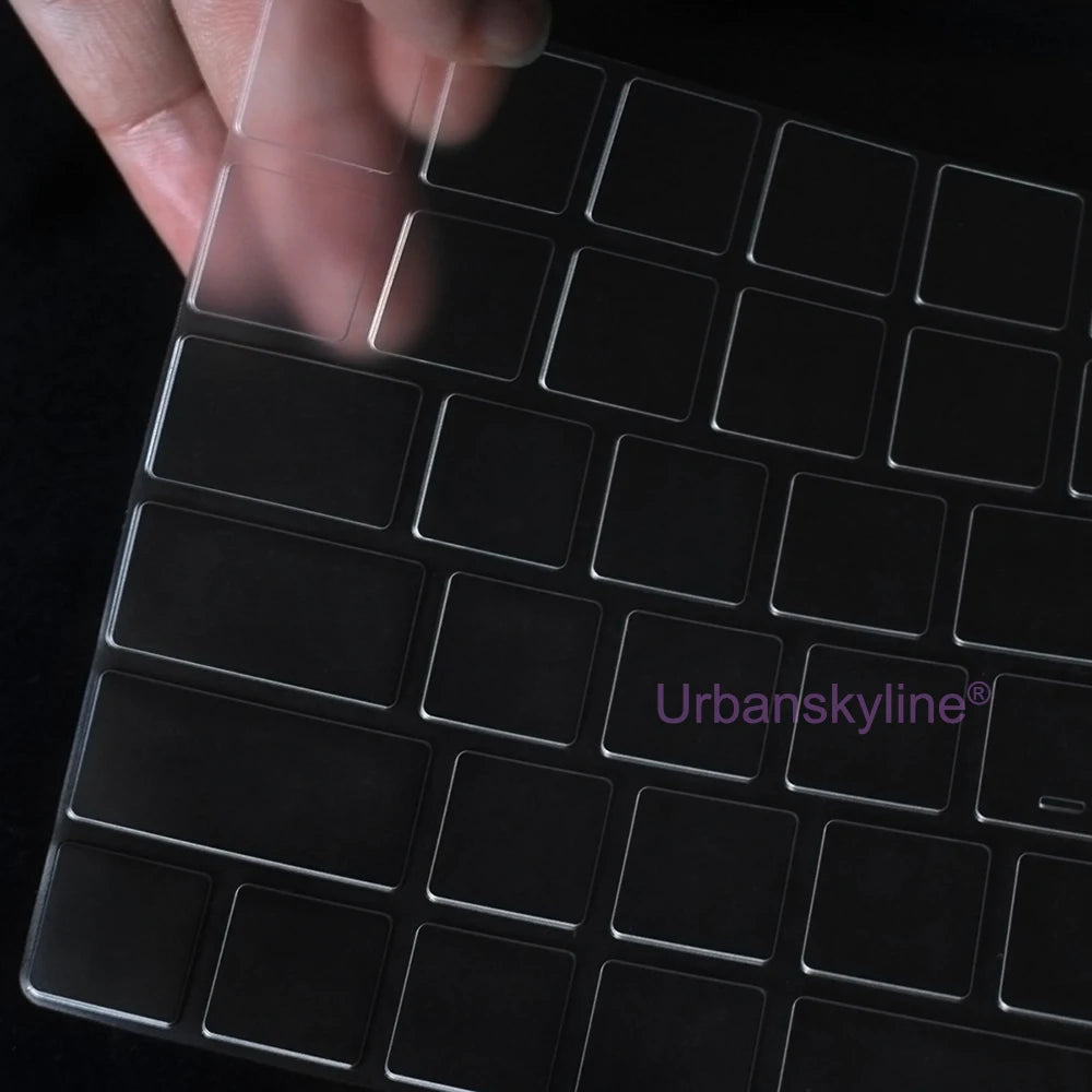 Una mano está presionando una cubierta de teclado de silicona sobre un teclado de portátil negro.