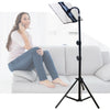 A woman is using an adjustable tripod tablet stand for her phone while sitting on a sofa.