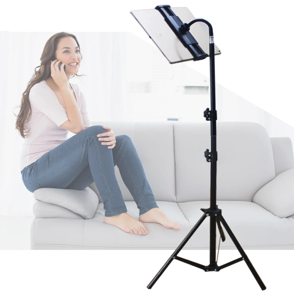 A woman is using an adjustable tripod tablet stand for her phone while sitting on a sofa.
