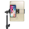 A beige iPad is mounted on an adjustable clamp, holding an iPhone in place.