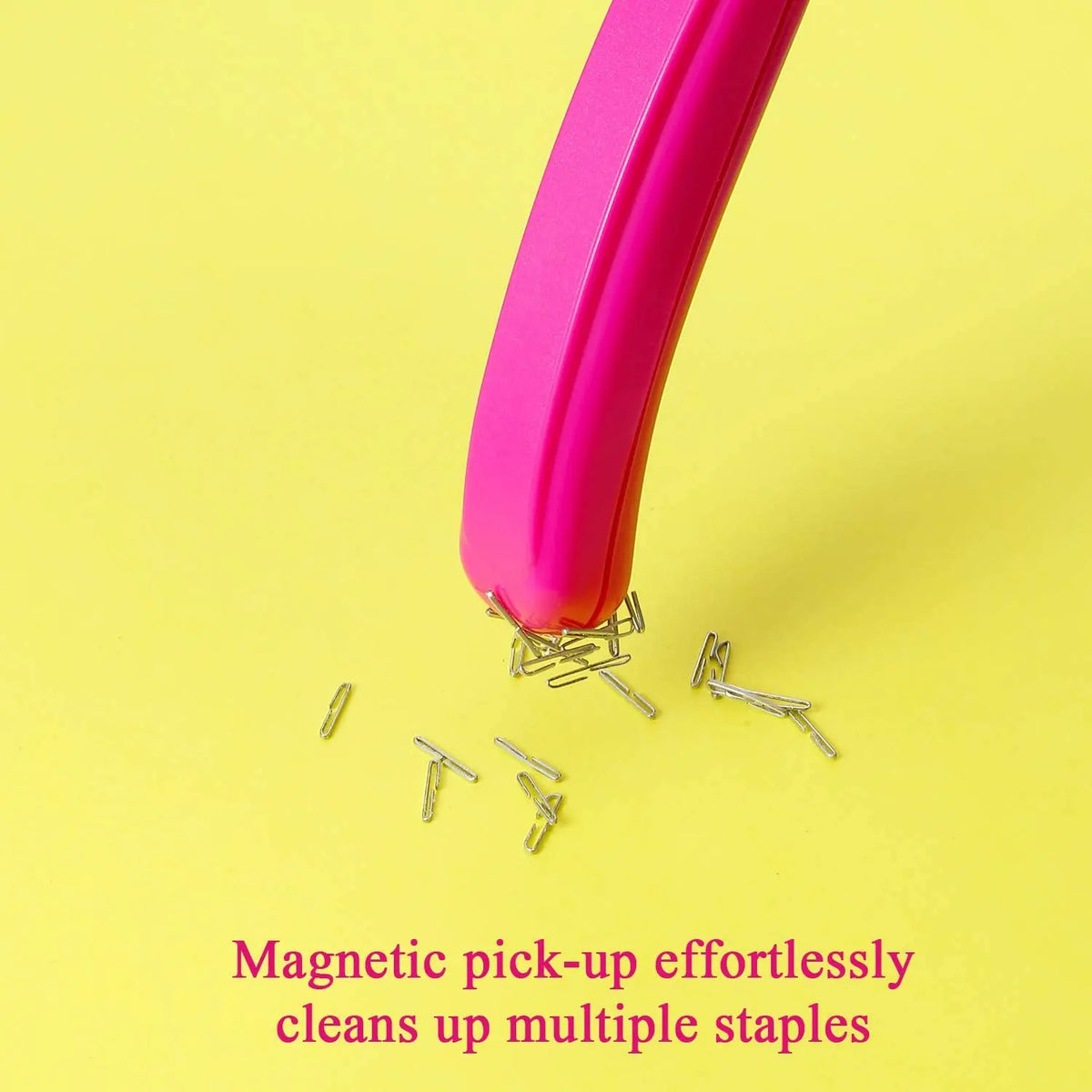 A pink magnetic pick-up tool effortlessly cleans up multiple metal staples on a yellow background.
