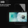 A close-up of a tempered glass screen protector being applied to a tablet screen, showing light transmittance.