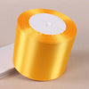 Roll of gold yellow satin ribbon with white batting visible inside