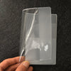 A clear PVC passport and ID holder wallet is held by a hand against a dark background.