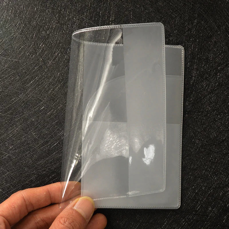 A clear PVC passport and ID holder wallet is held by a hand against a dark background.