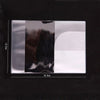 A transparent PVC passport and ID holder wallet with a black background showing various shades of gray and white.