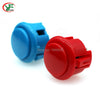A close-up view of a red arcade push button game switch and a blue switch.