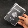 A hand holds a transparent PVC passport and ID holder wallet with the United States of America emblem visible.