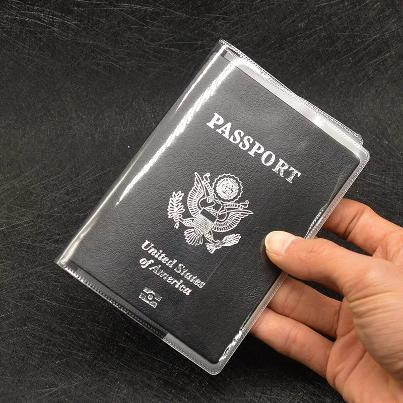 A hand holds a transparent PVC passport and ID holder wallet with the United States of America emblem visible.