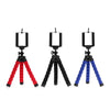 Three flexible mini tripods in black, red, and blue with phone clips for smartphone and camera.