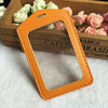 Orange PU leather ID card holder with a leather strap resting in a wooden box surrounded by pink and white flowers.