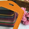Orange PU leather ID card holder with a leather strap and a stack of colorful cards.