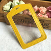 Yellow PU leather ID card holder with a cutout for a lanyard, resting on a wooden box.