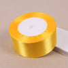 A roll of gold yellow satin ribbon with a white core.