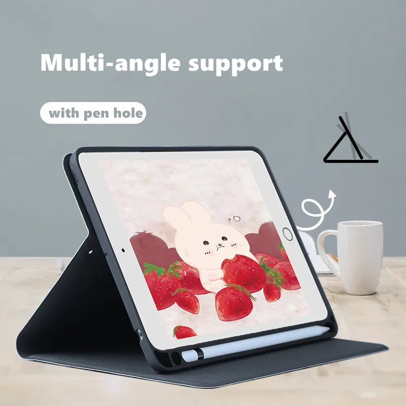 A tablet displaying a pink composition book cover design with a rabbit and strawberries, shown with a multi-angle support.