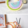 Puente de arcoíris de bloques de madera en colores pastel dispuestos en patrón circular.
