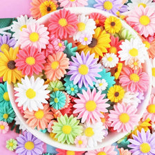 A colorful assortment of pink, yellow, and white sunflower flatback resin cabochons for crafts